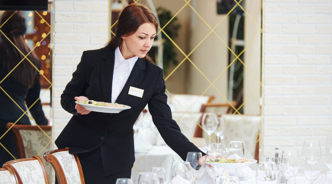 banquet server delivering food to a table