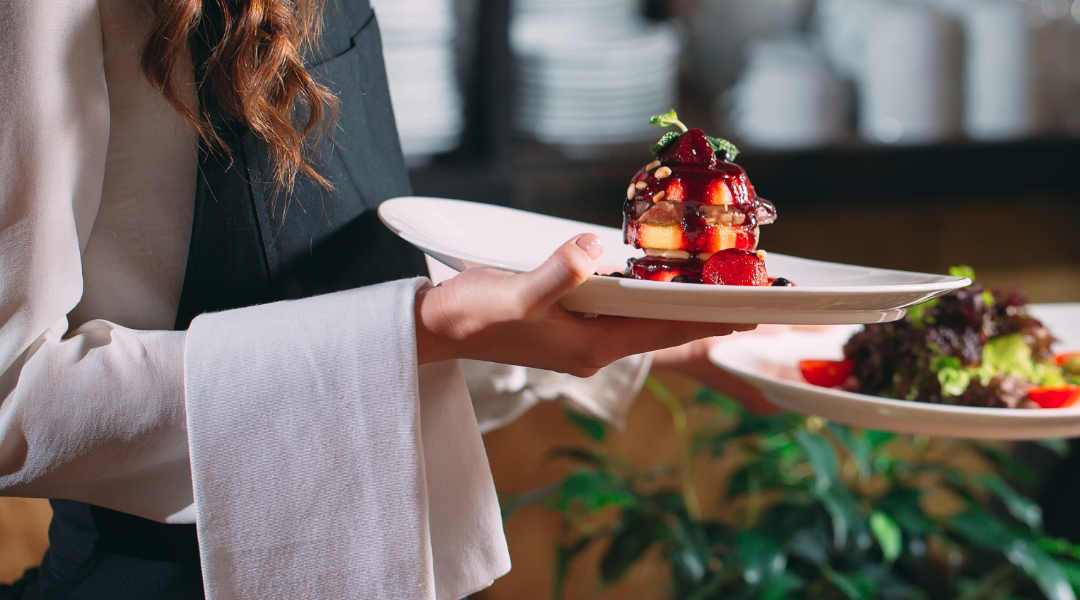 woman carrying two plates of food