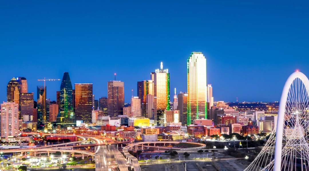 Dallas skyline against a deep blue sky.