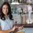 Hospitality staff member holding a clipboard and smiling into the camera