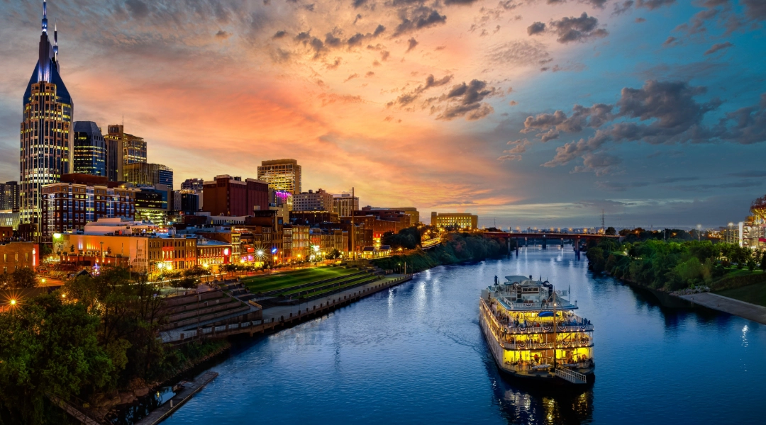 Vibrant photo of Nashville, TN, showing the night life against a beautiful sunset.